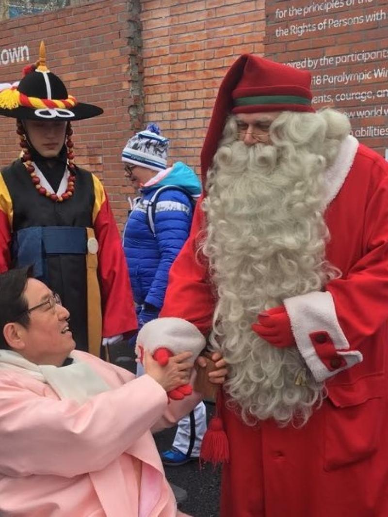 Santa Claus shaking hands with a wheelchair athlete