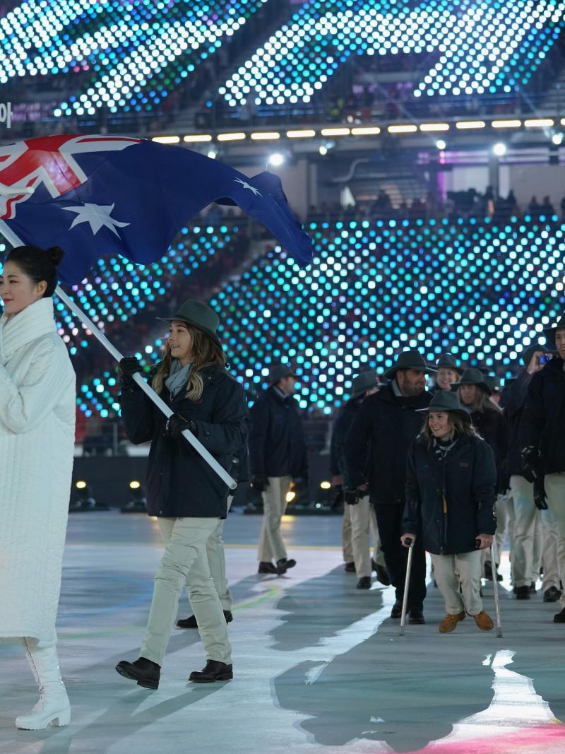 a female snowboarder carrying the flag of Australia