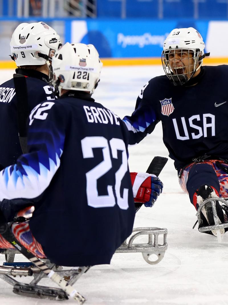 Para ice hockey players celebrate on the ice