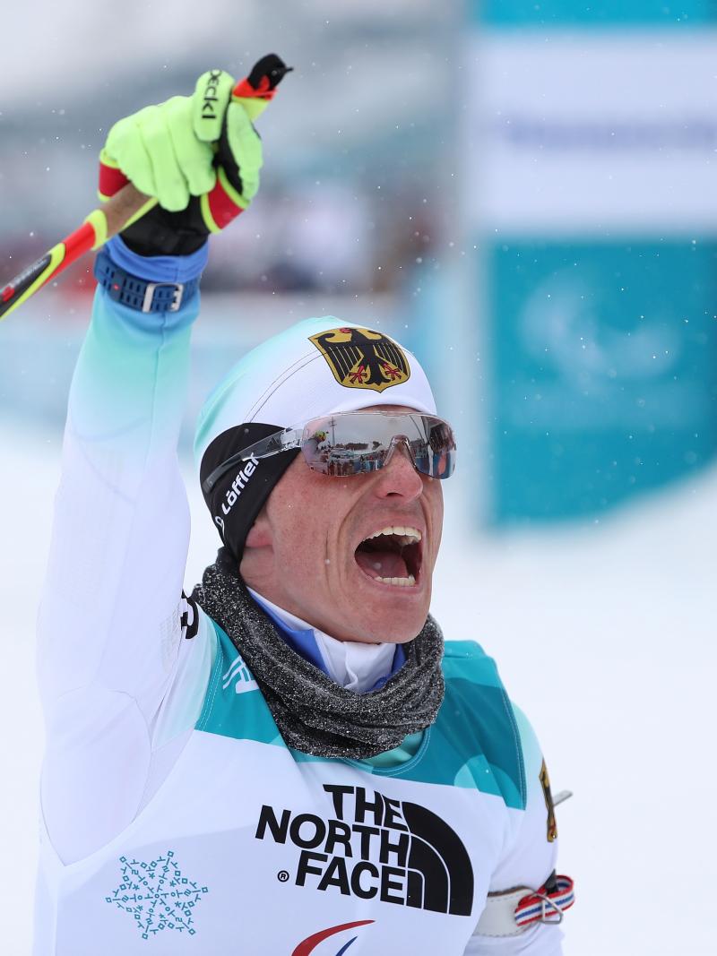 a male Para sit skier punches the air