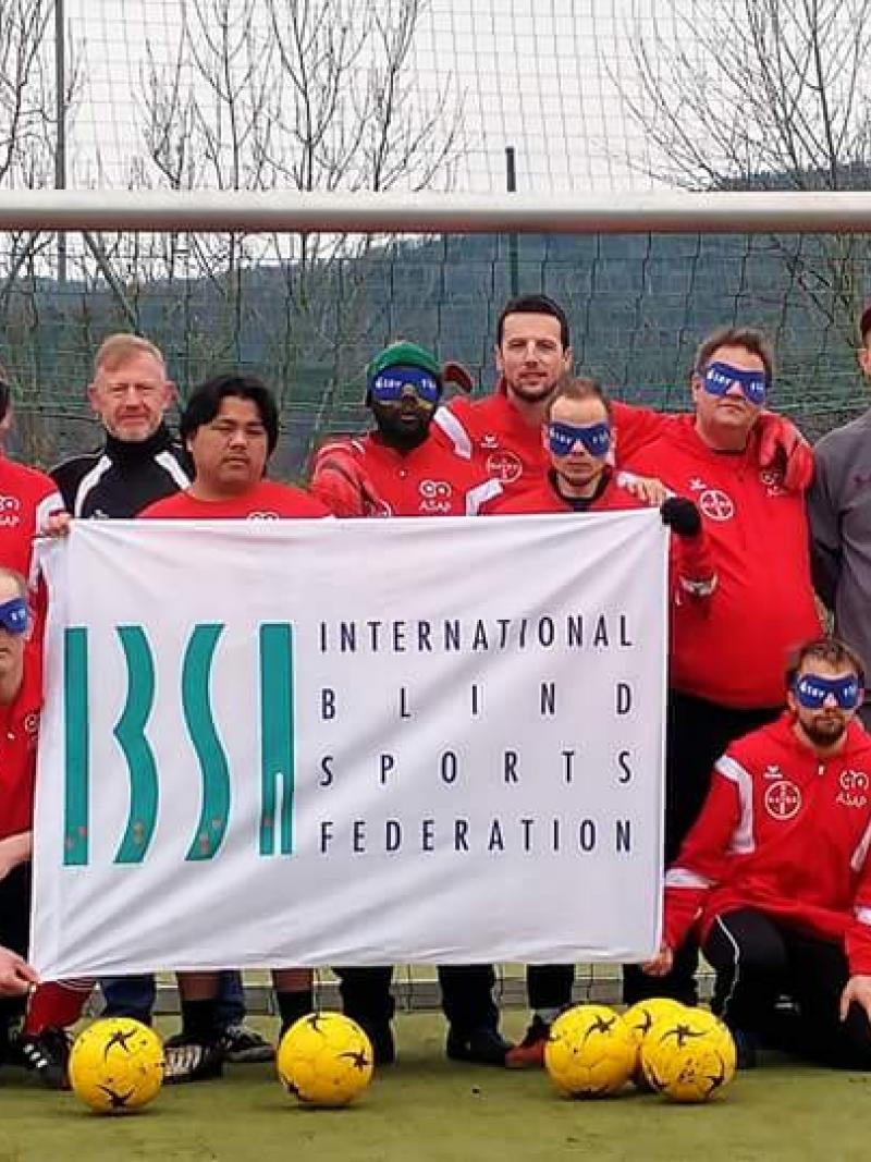 a group of blind footballers line up in goal