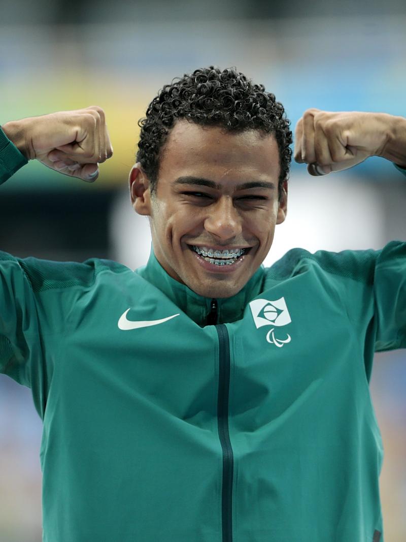 a male athlete raises his fists on the podium