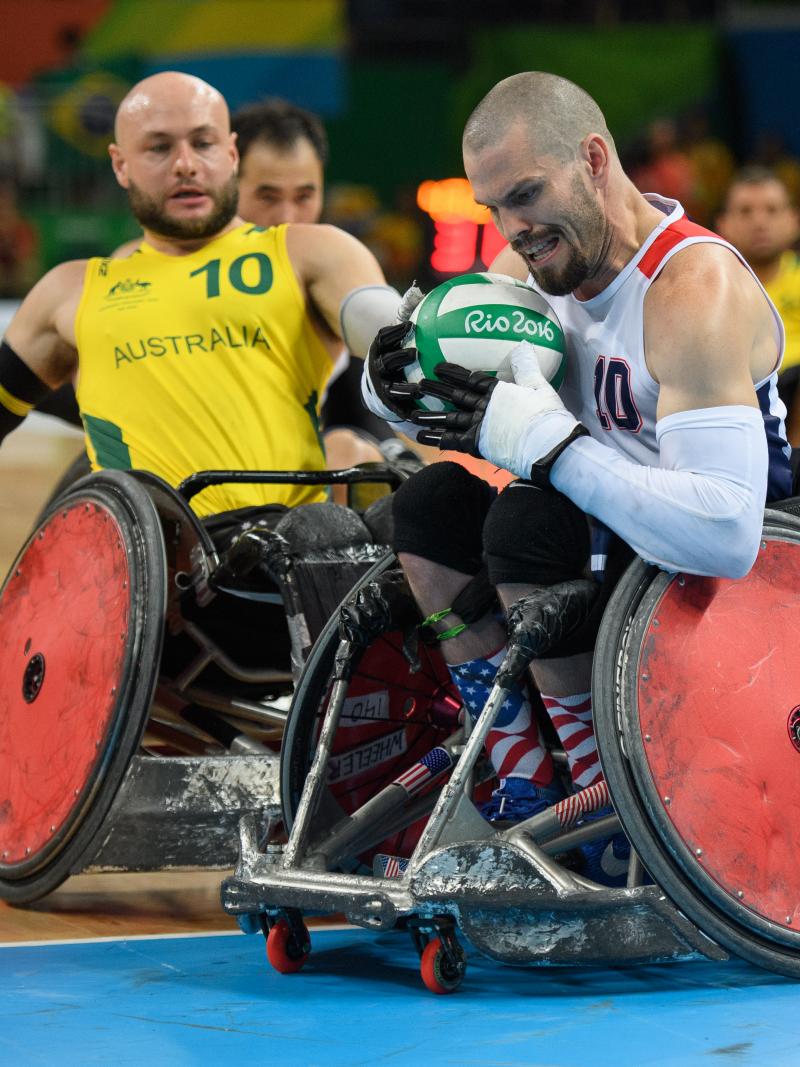 two male wheelchair rugby players fight for the ball