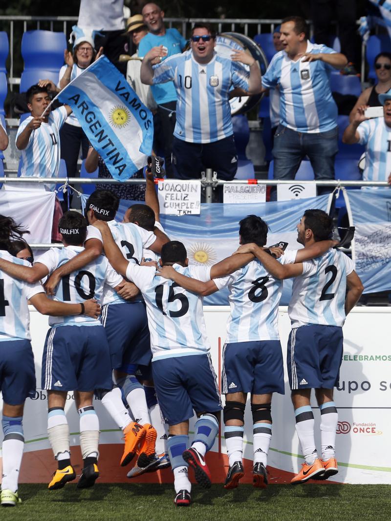 a group of blind footballers celebrating with the crowd