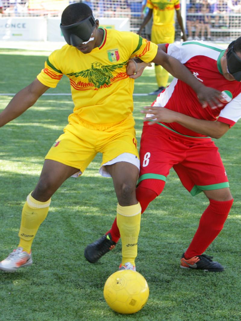 Two blind football players battle for the ball