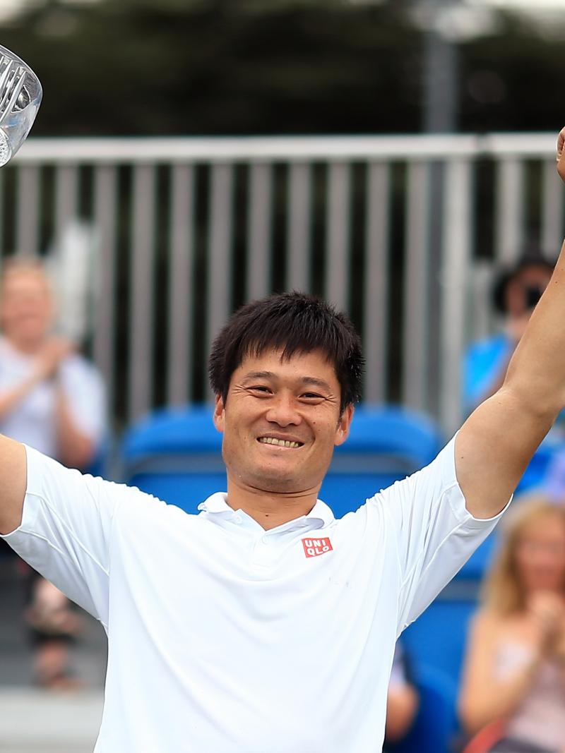 Male wheelchair tennis player Shingo Kunieda holds up a glass trophy