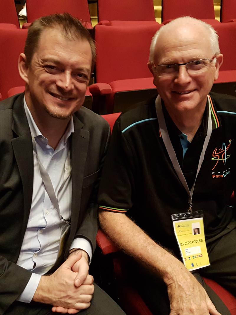 two men, Andrew Parsons and Barry Couzner, smiling and shaking hands