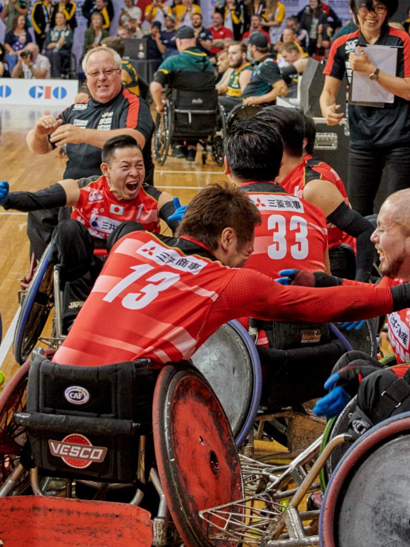 a group of Japanese wheelchair rugby players celebrate on the court