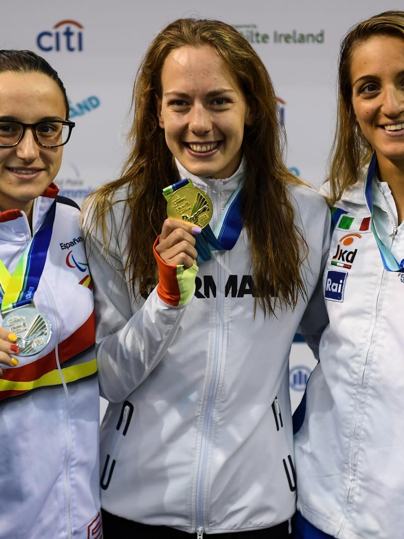 three female Para swimmers, with Naomi Maike Schnittger in the centre, holding up their medals