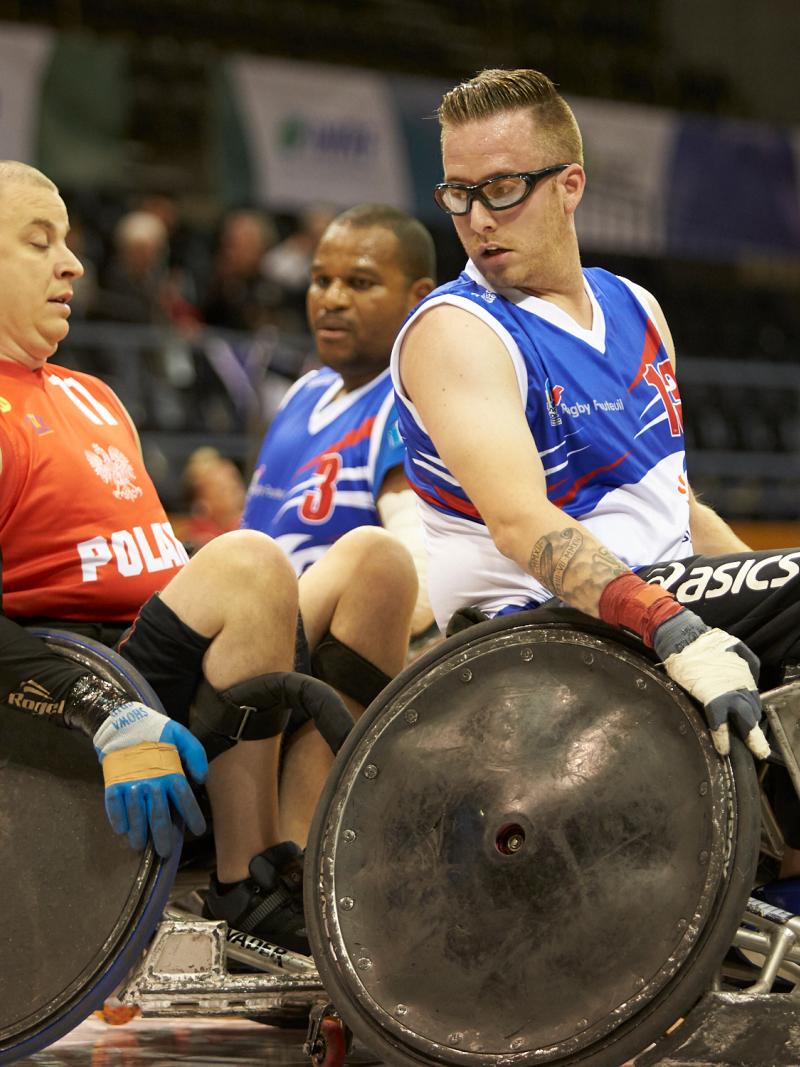 French and Polish wheelchair rugby players in action on the court