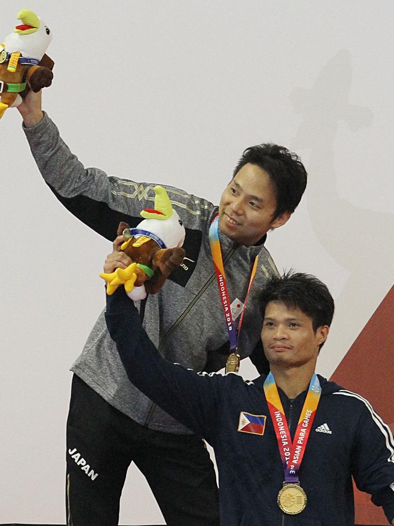 male Para swimmers Daisuke Ejima and Ernie Gawilan on the podium raising their arms