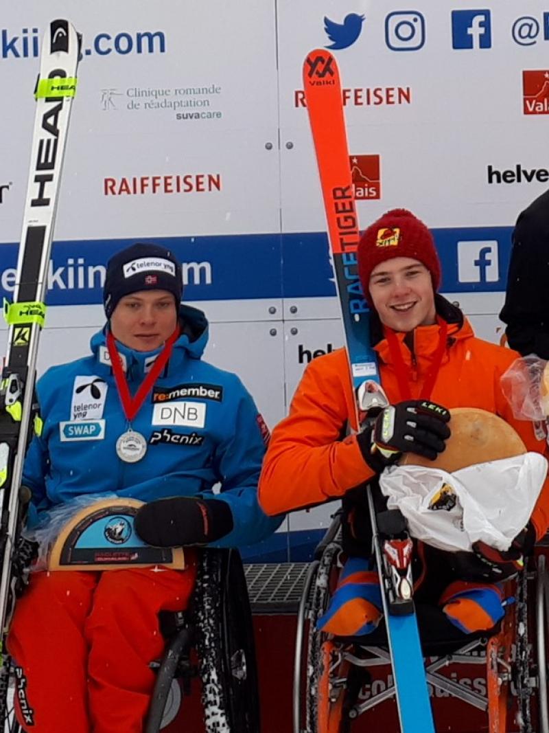 three Para alpine skiers holding up wheels of cheese on the podium