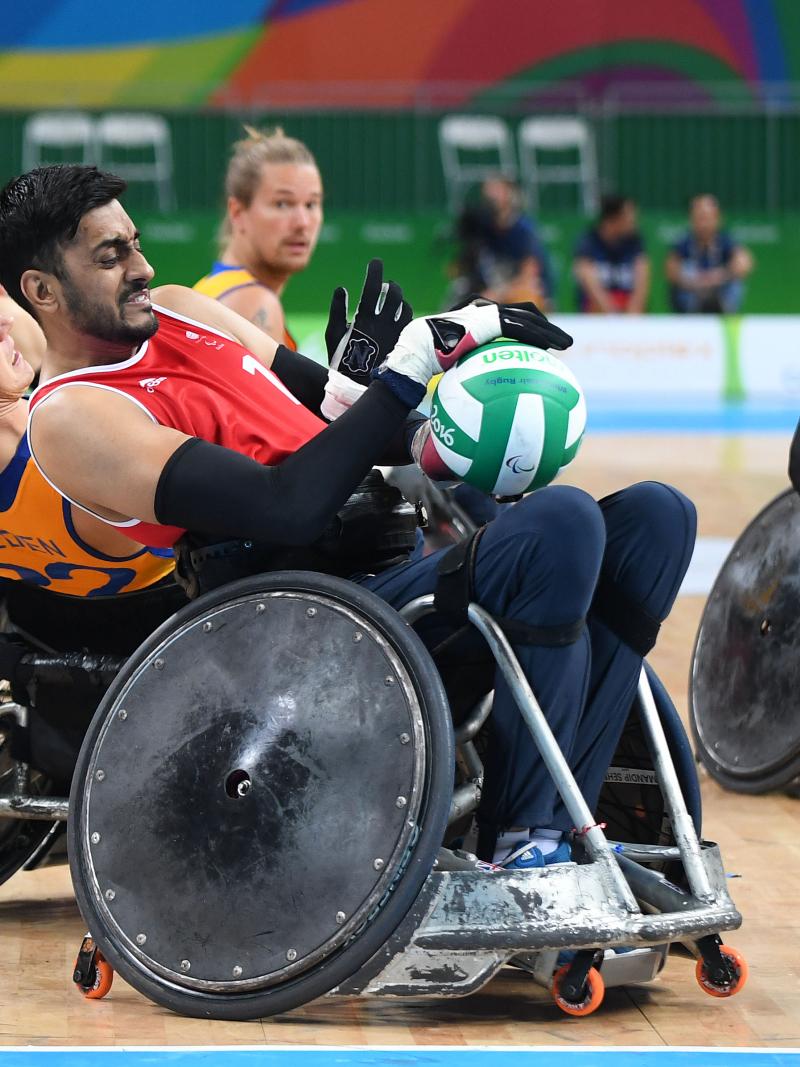 wheelchair rugby players grappling for the ball