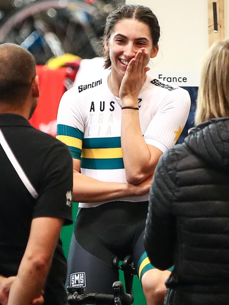 female Para cyclist Paige Greco smiles at two team officials