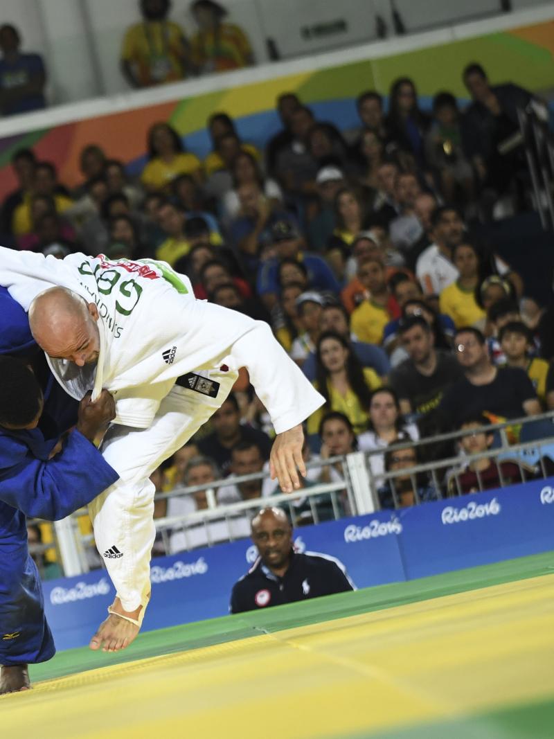 male Para judoka Sam Ingram throws another judoka onto the mat