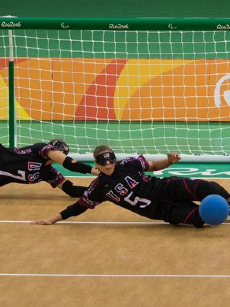 female goalball players Eliana Mason and Amanda Dennis dive to stop the ball
