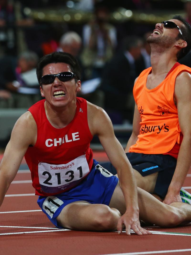 Chilean athlete and his guide on the floor exhausted after a race