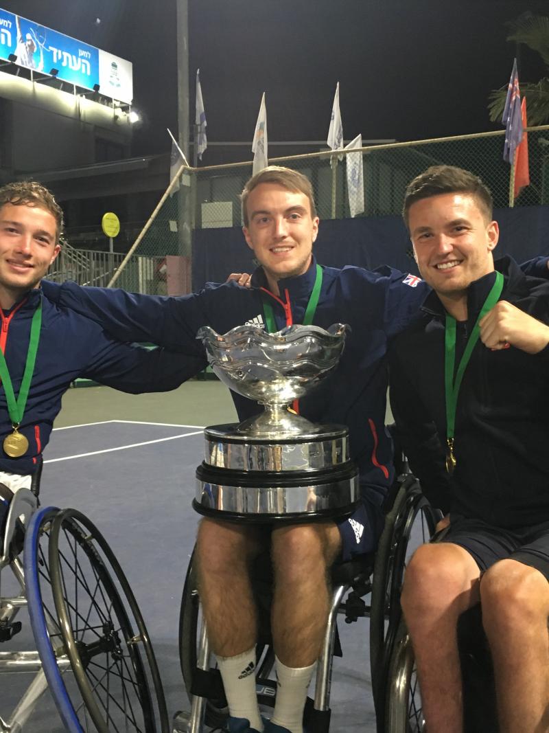 British players smile at the camera while showcasing the trophy