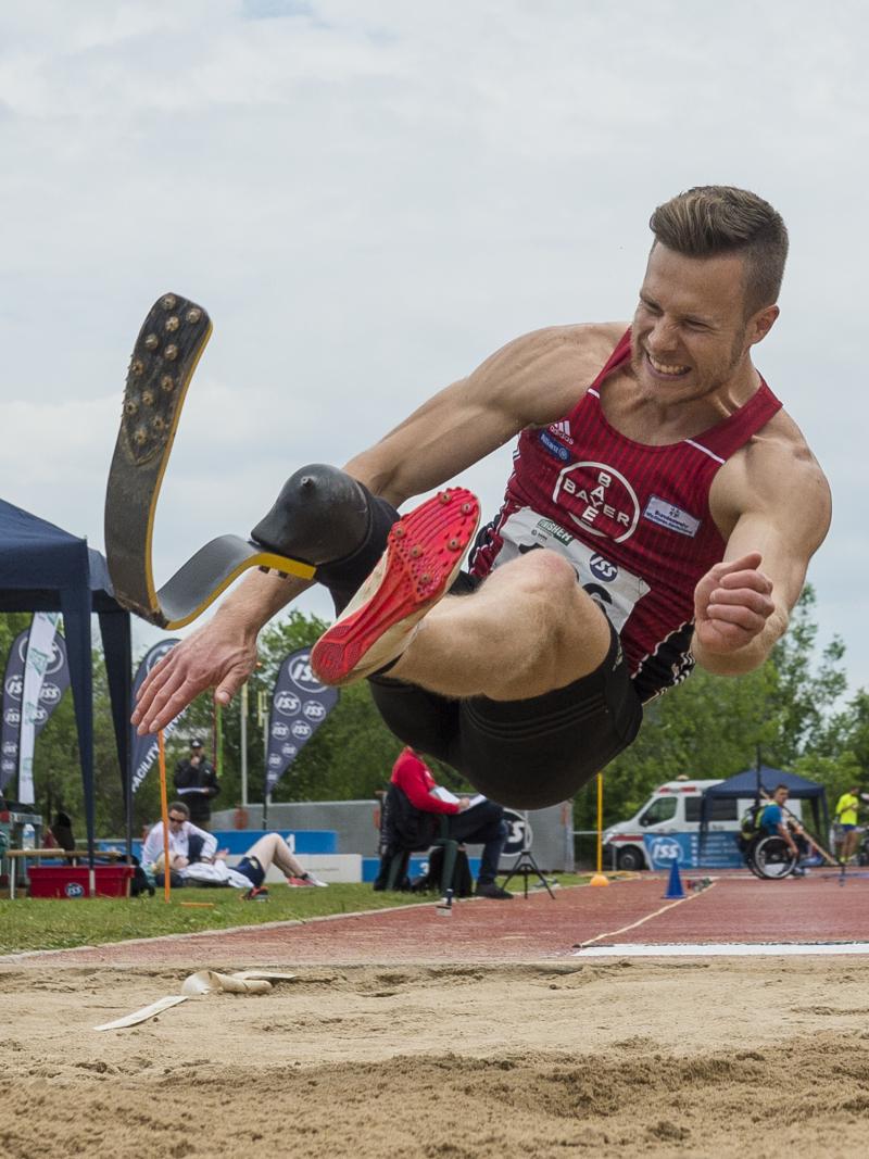 A man with a prosthetic leg competing in long jump