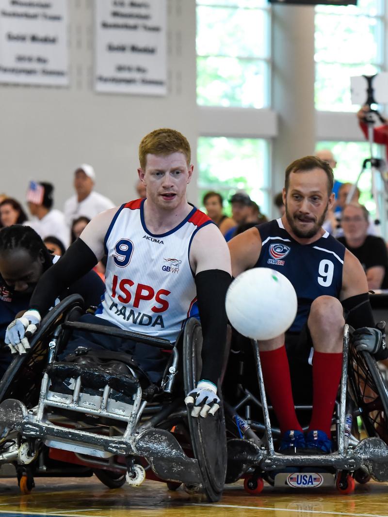 Two male wheelchair rugby players collide trying to fight for a loose ball