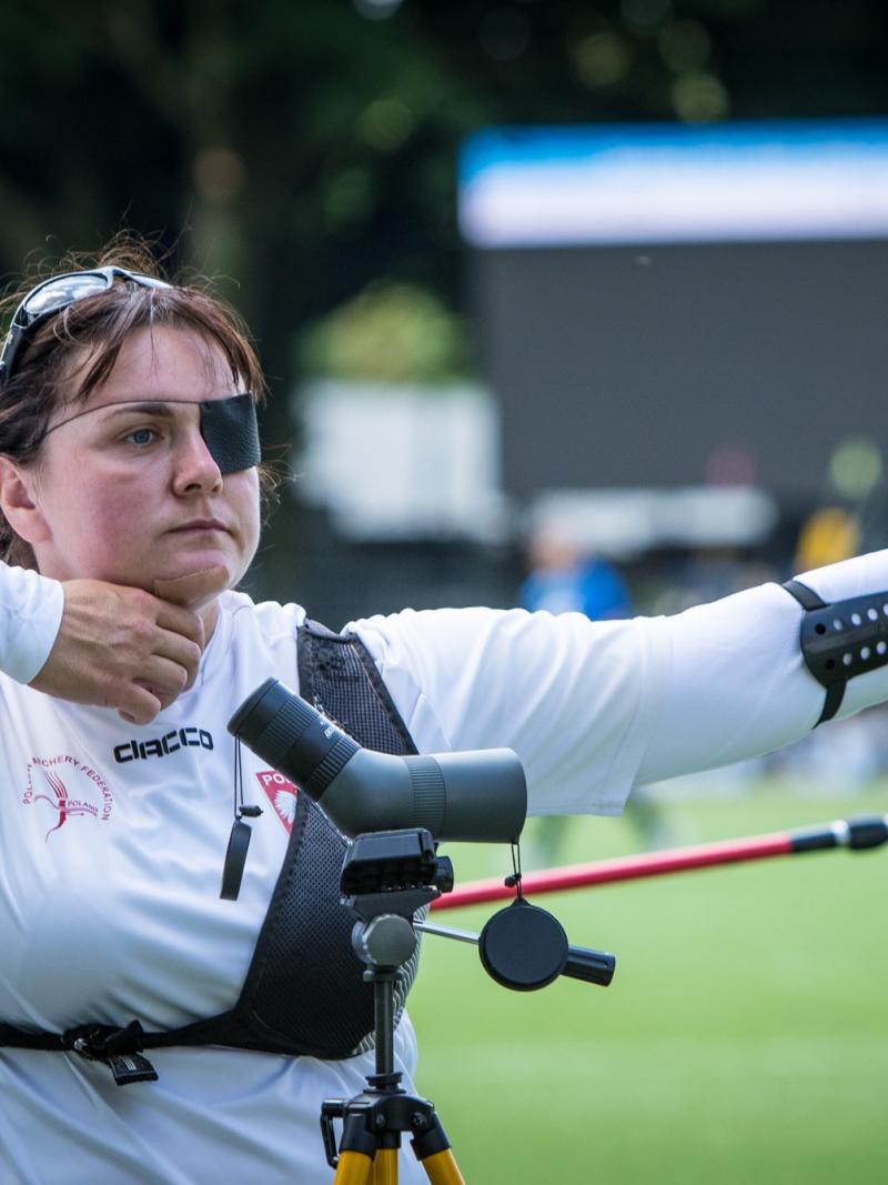 Polish woman with eye patch looks on after shooting her arrow