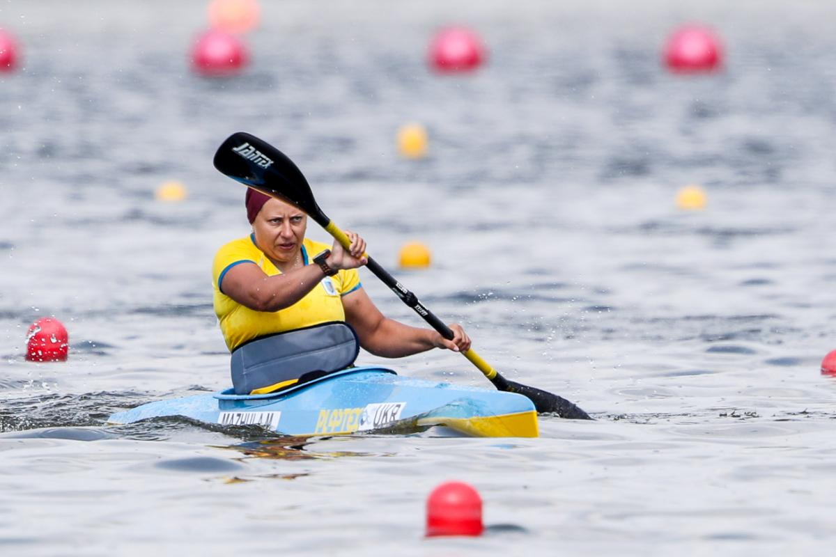 a female Para canoeist mid-stroke on the water