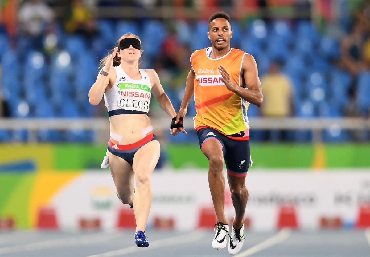 a female vision impaired runner and her guide sprint for the line