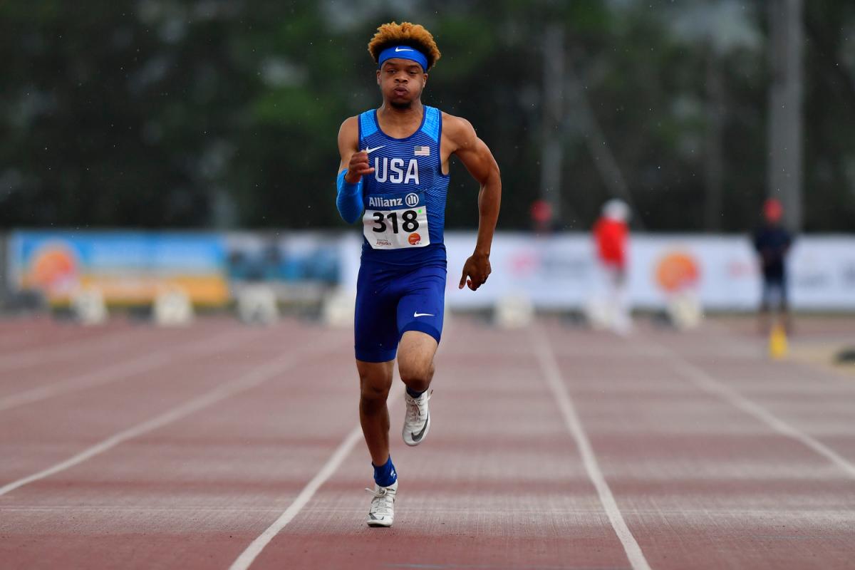 African American teenage male sprints on the track