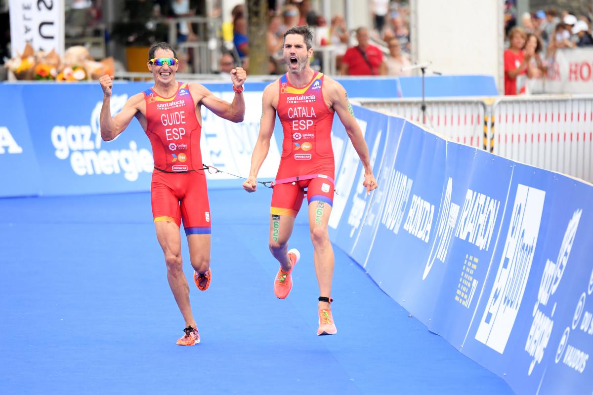 Vision impaired triathlon and his guide celebrate at the finish line