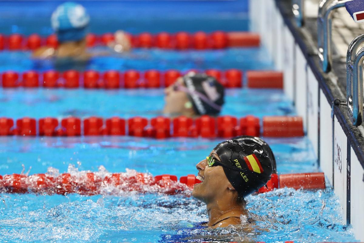 a female Para swimmer celebrates in the pool