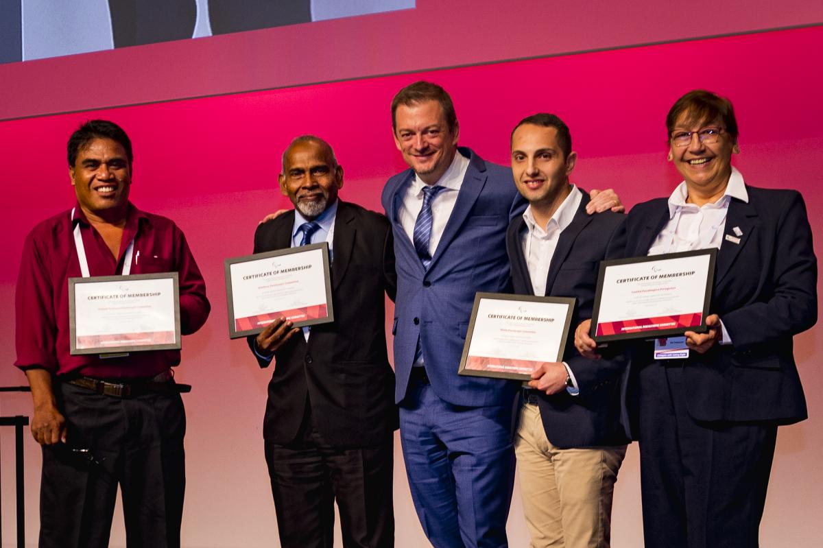 IPC President poses with three NPC presidents holding certificates of membership