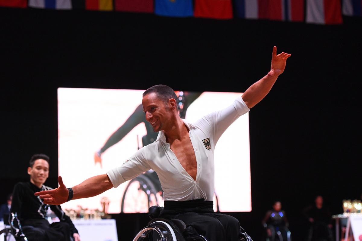 German male dancer spreads arms during performance