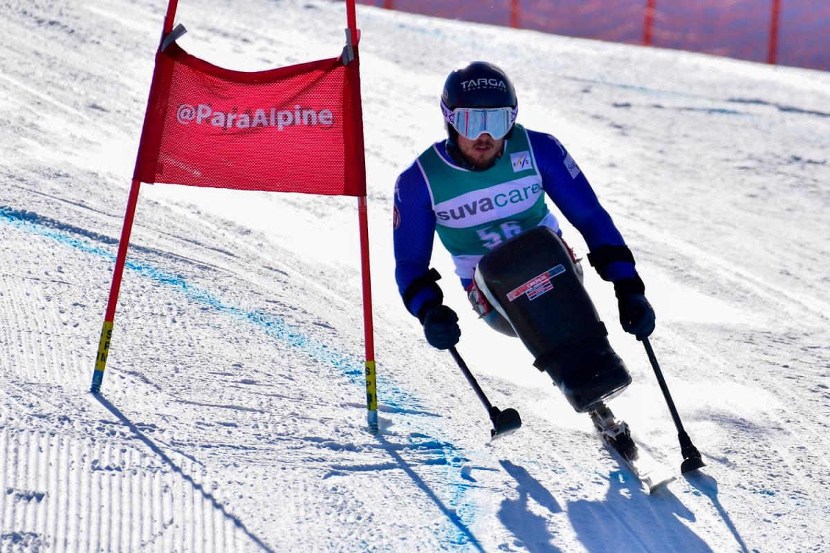 Male sit skier rides down mountain