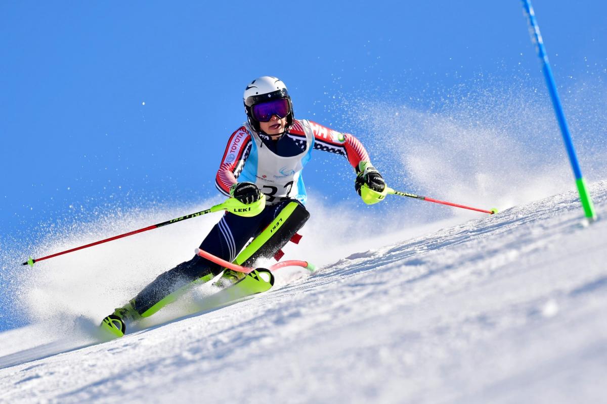 Male standing skier makes a turn