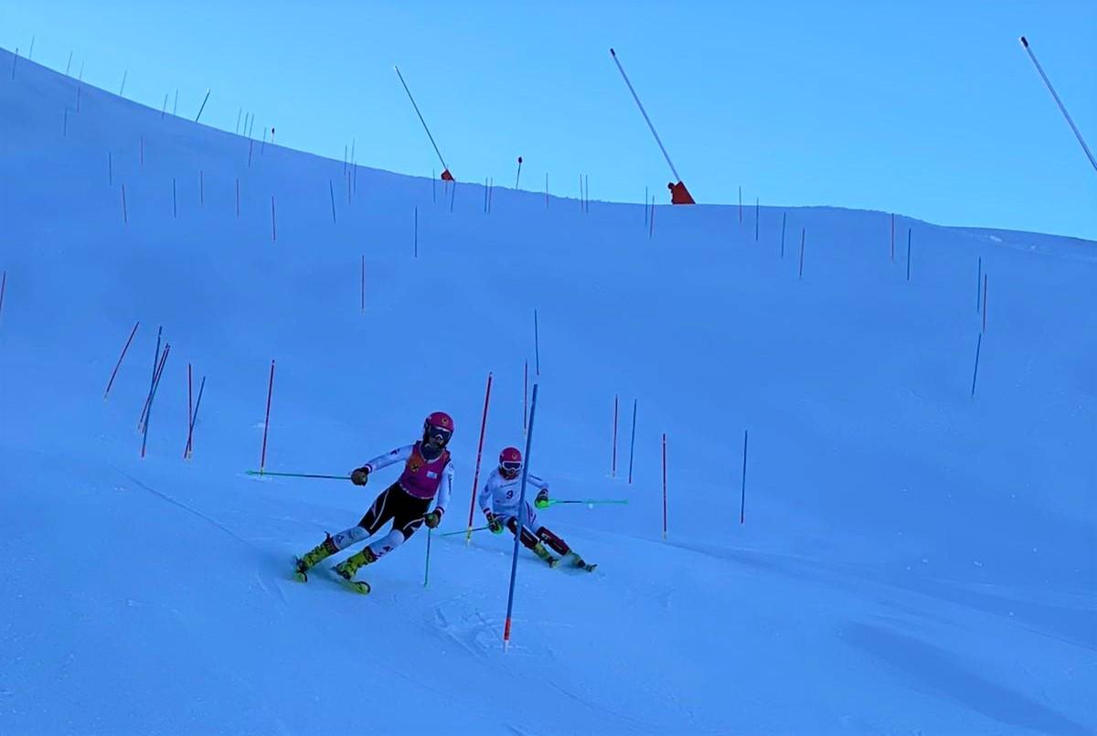 A vision impaired Para alpine skier following the guide in a slalom competition