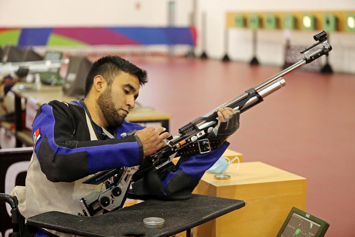 A man loading a rifle in a shooting range