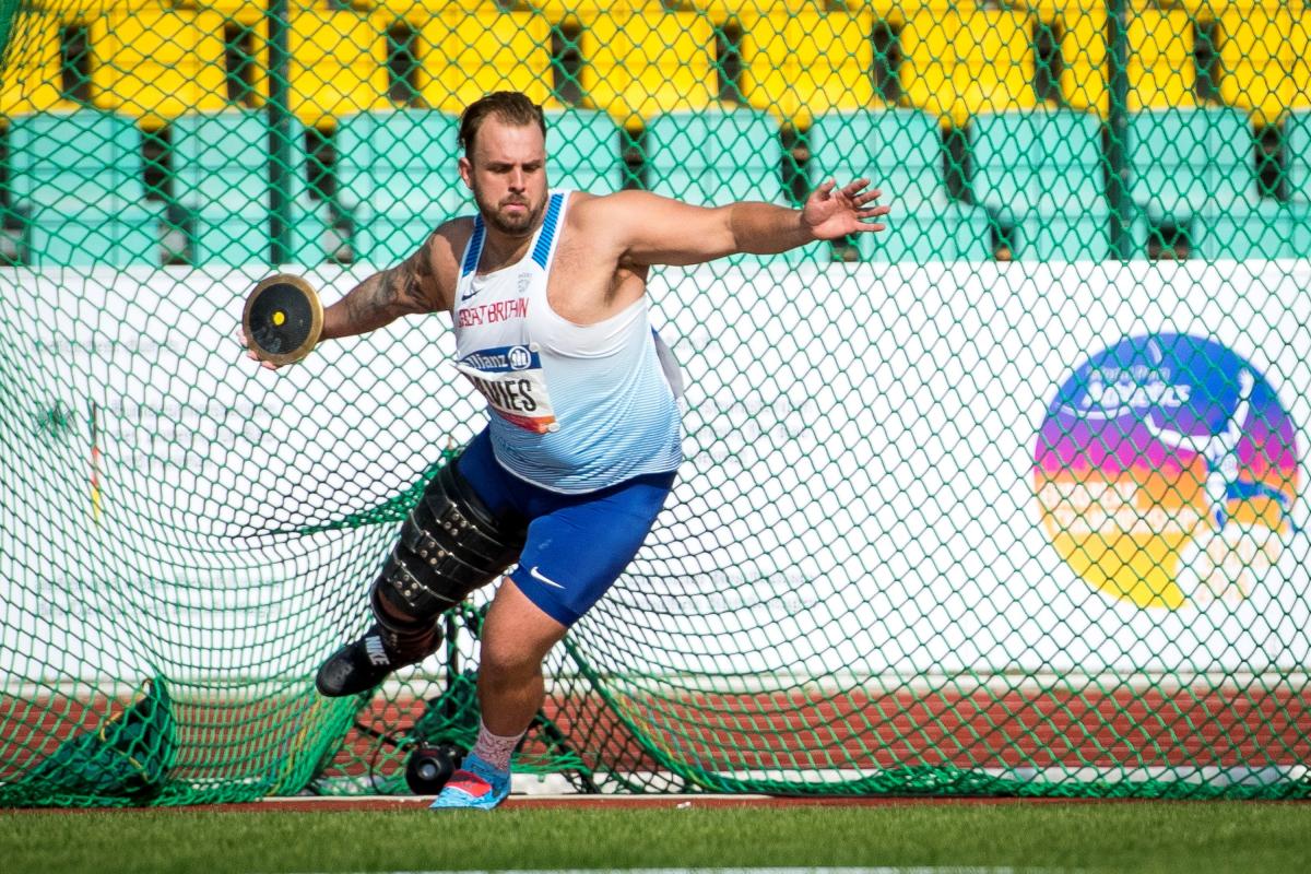 A man with a prosthetic leg competing in shot put