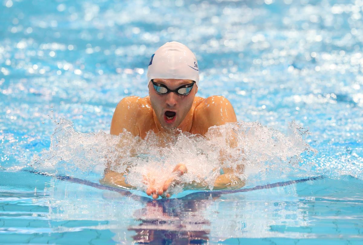 A man swimming breaststroke in a swimming pool