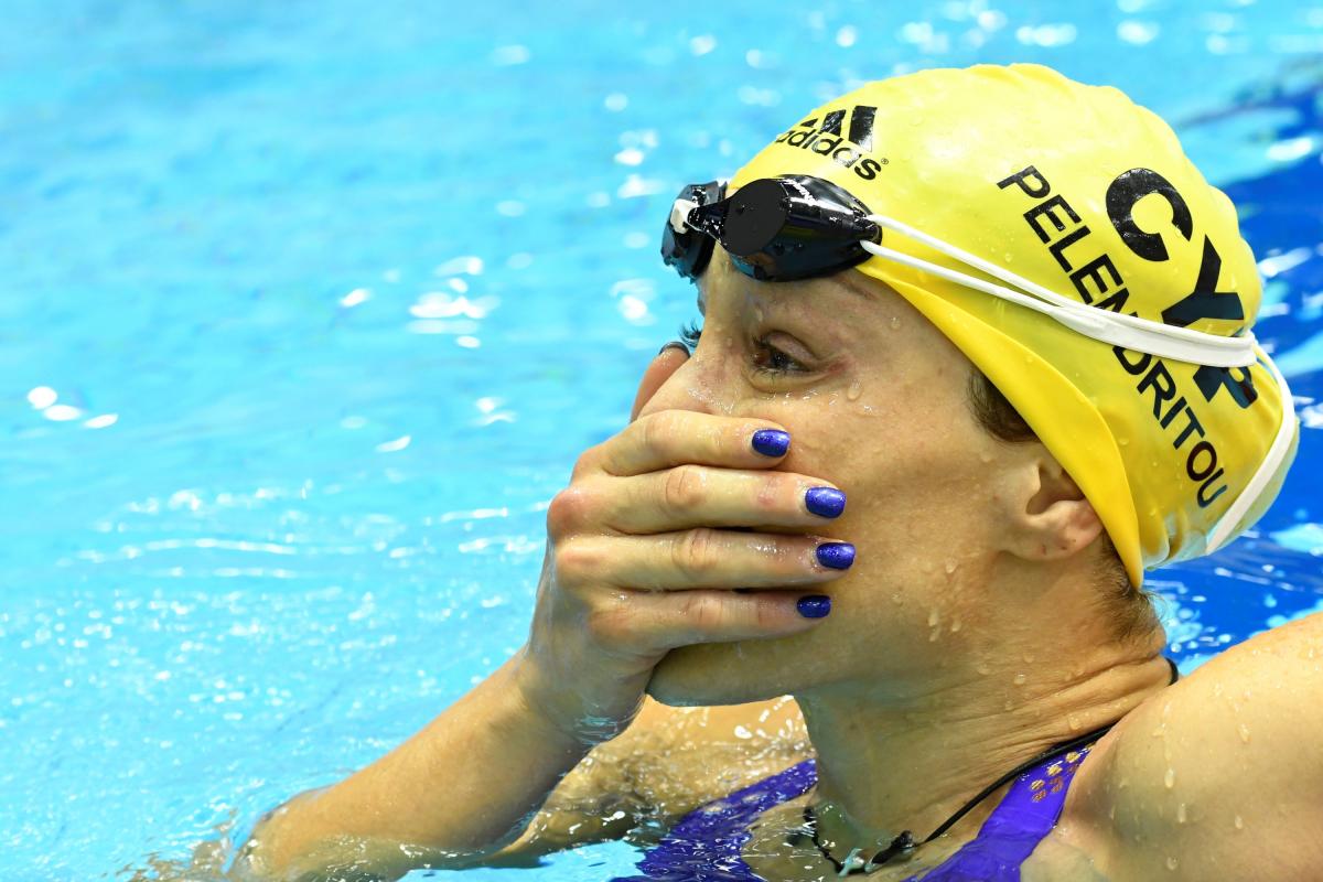 A woman in a swimming pool with a hand in her mouth as in surprise