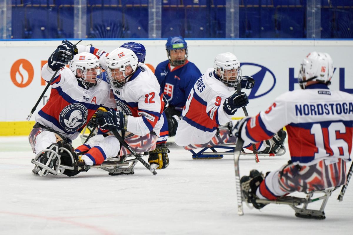 A group of Norwegian Para ice hockey players celebrating on ice