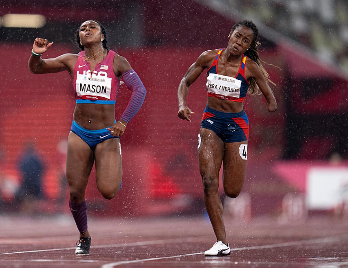 Two female runners in a track under rain