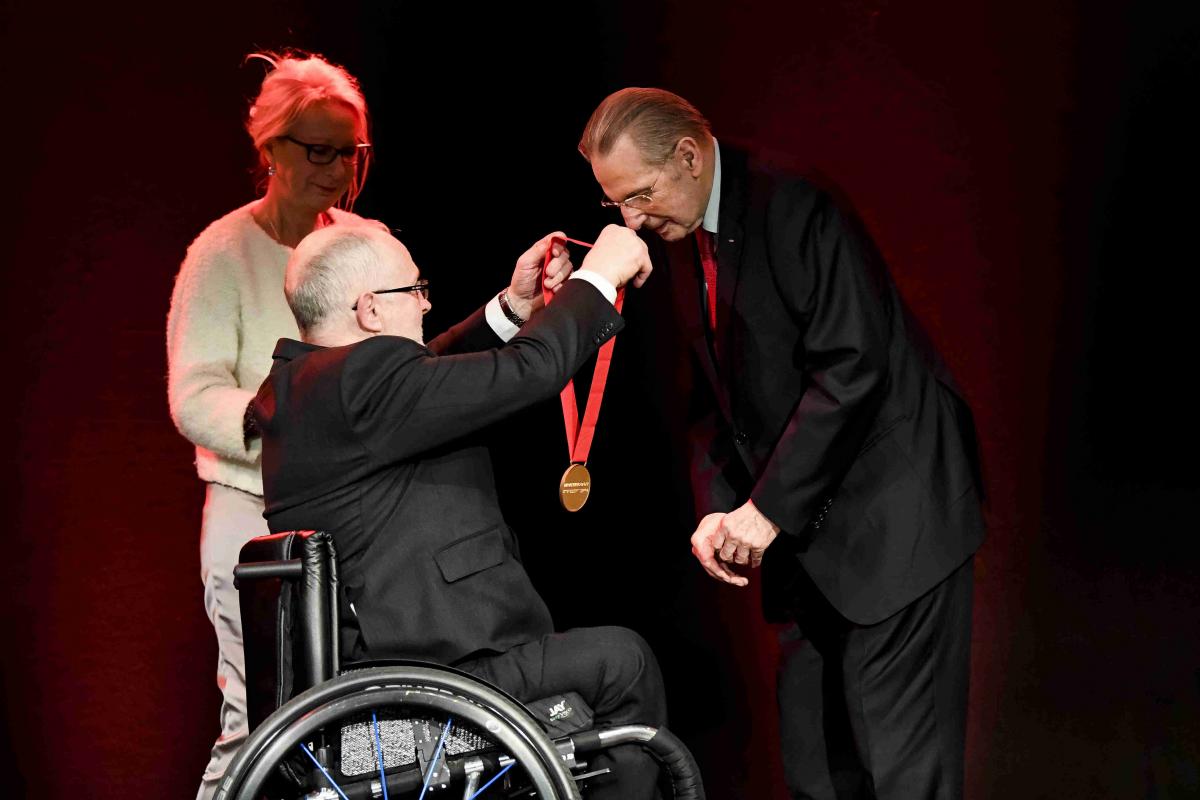 Man puts on medal of honor on another man