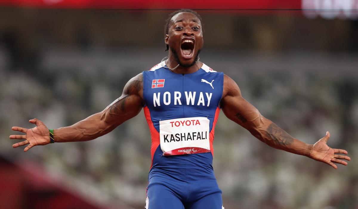 A man celebrates the victory with open arms and a big smile