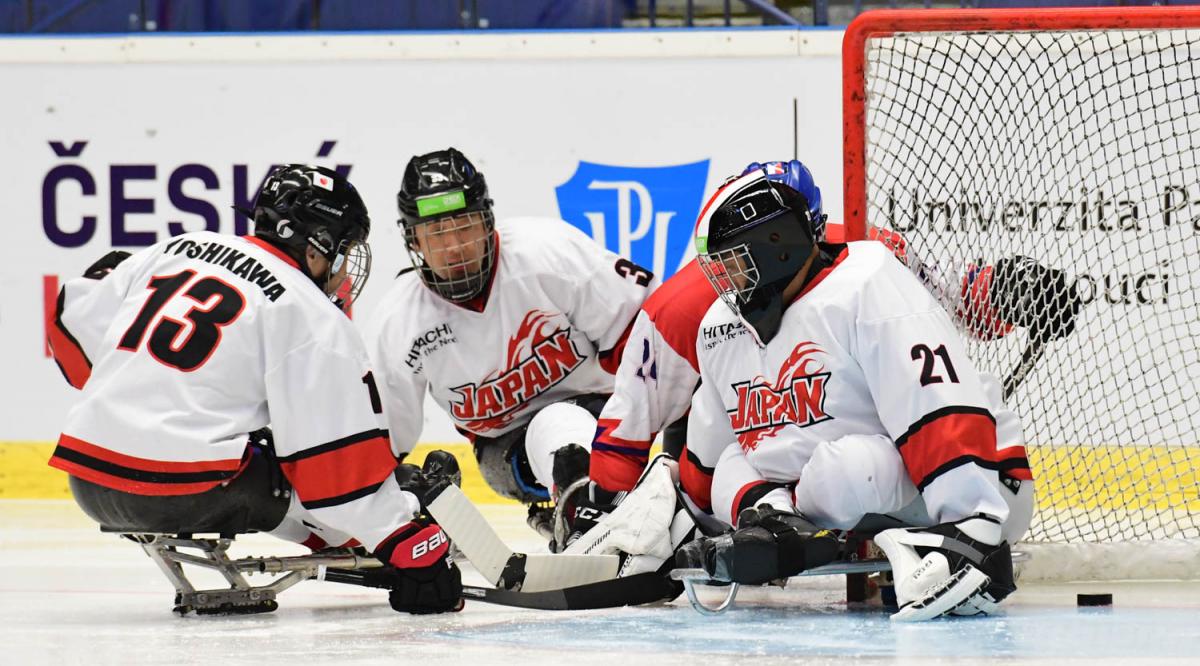 Para ice hockey players trying to find the puck on the ice