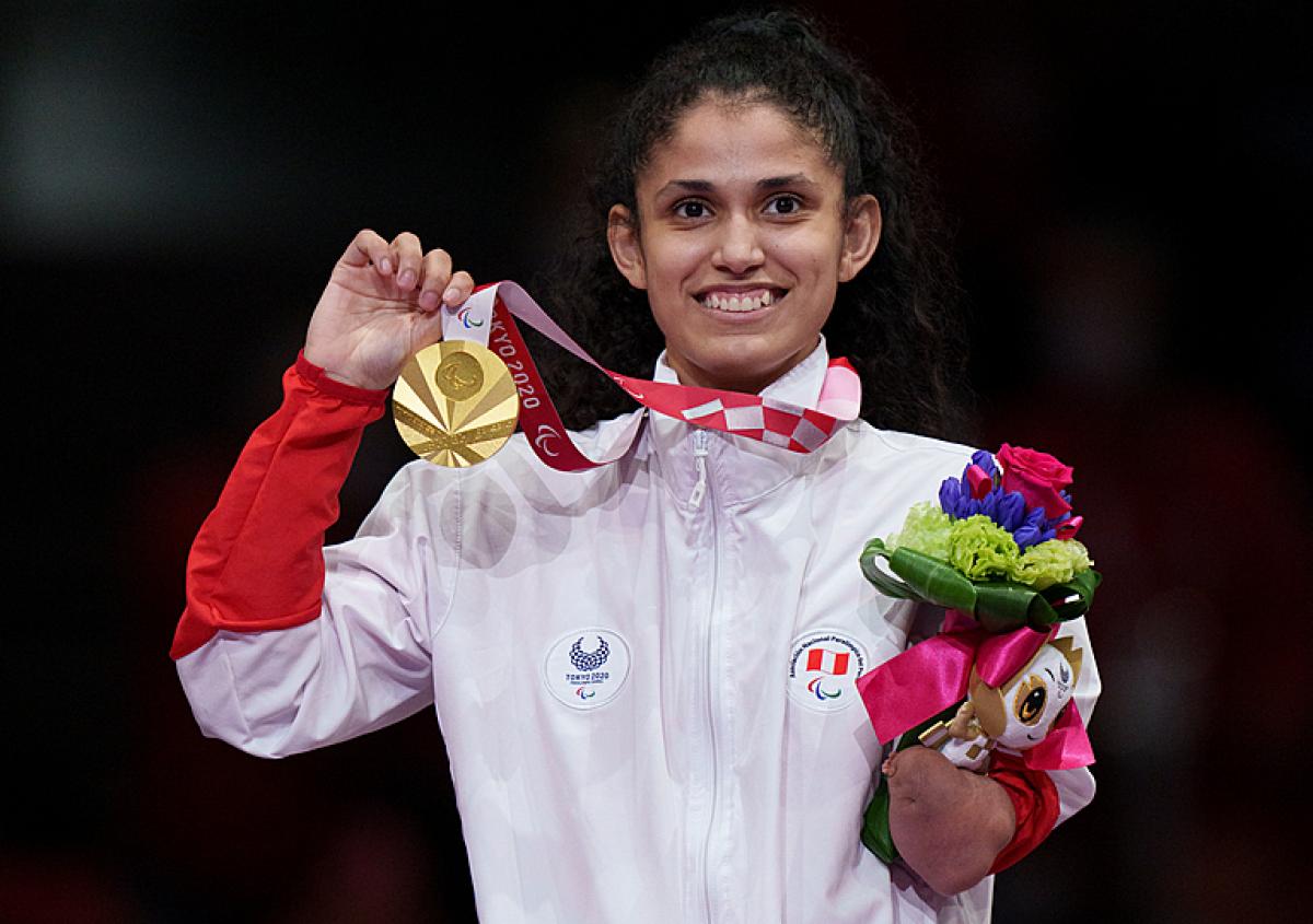 Peruvian taekwondin Angelica Espinoza smiles on the podium while holding the gold medal