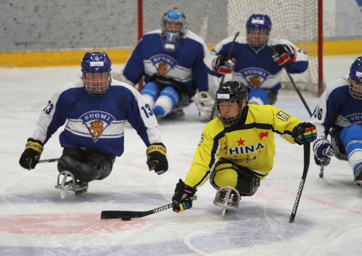 Men chasing the puck on a sled