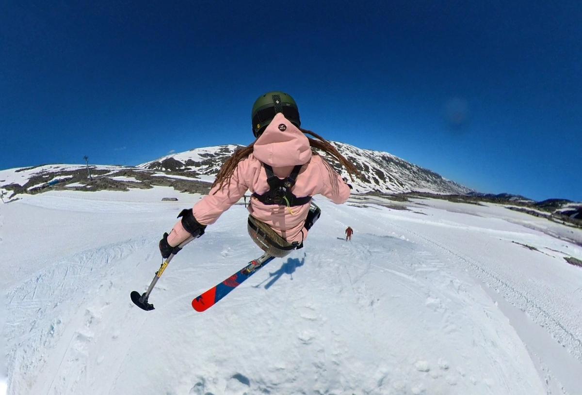 A female sit-skier seen from behind in a freestyle slope