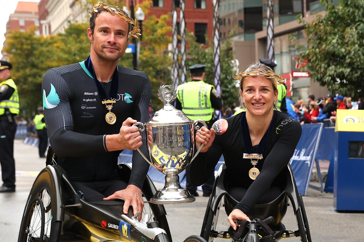 A man and woman pose with the trophy