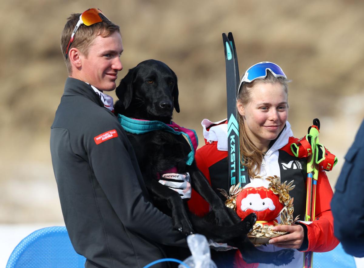 Gold medallist Carina Edlinger of Austria looks on with her guide dog Riley following the Women's Sprint Free Technique Vision Impaired Final flower ceremony in the Beijing 2022 Paralympic Winter Games at Zhangjiakou National Biathlon Centre. 