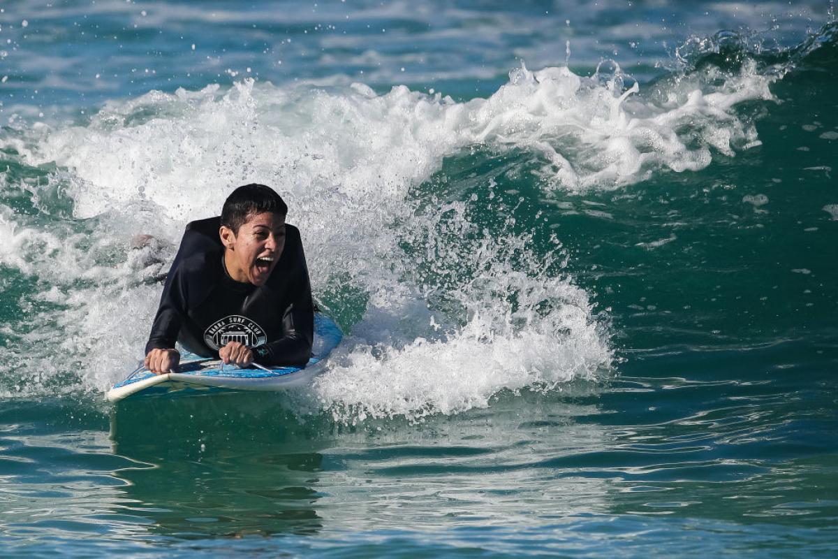 Brazil's Monique Oliveira laughs as she surfs a wave at Barra beach.